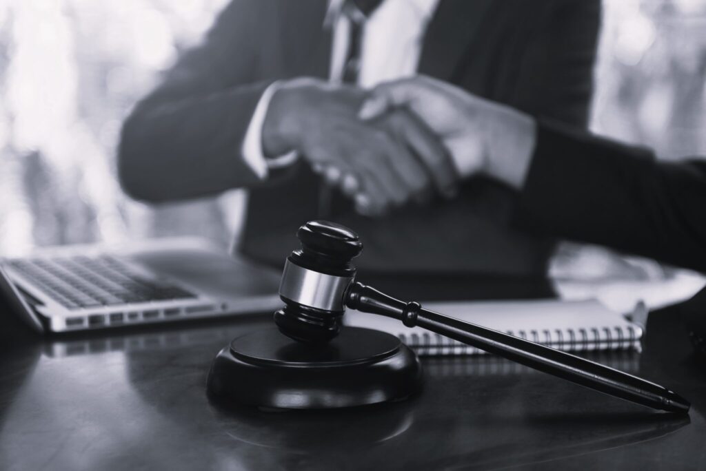 middle-age-partner-lawyers-attorneys-shaking-hands-2022-09-29-17-37-40-utc-scaled-1